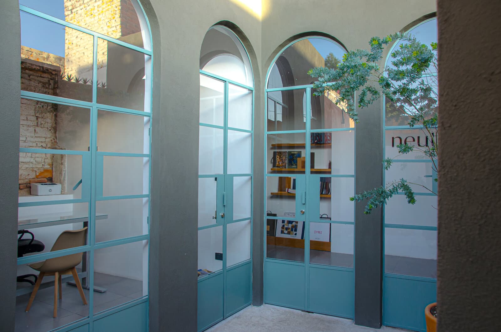 Oficina privada de Melchor con escritorio, silla de trabajo y una ventana en arco.